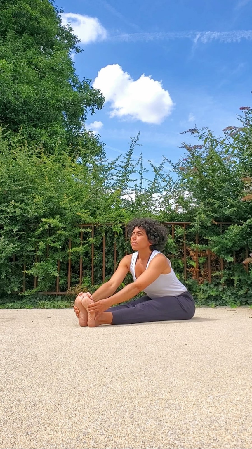 Nancy en posture de yoga assise en extérieur